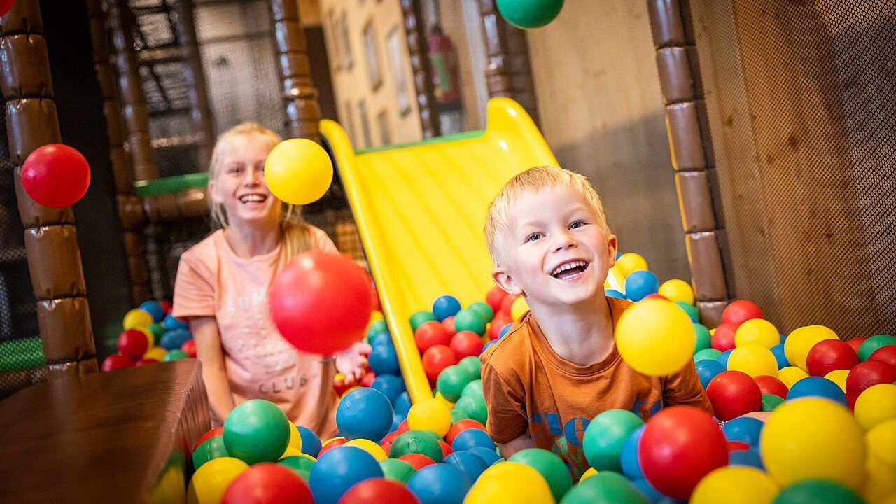 Zwei Kinder spielen im Bällebad einer Indoor-Spielscheune