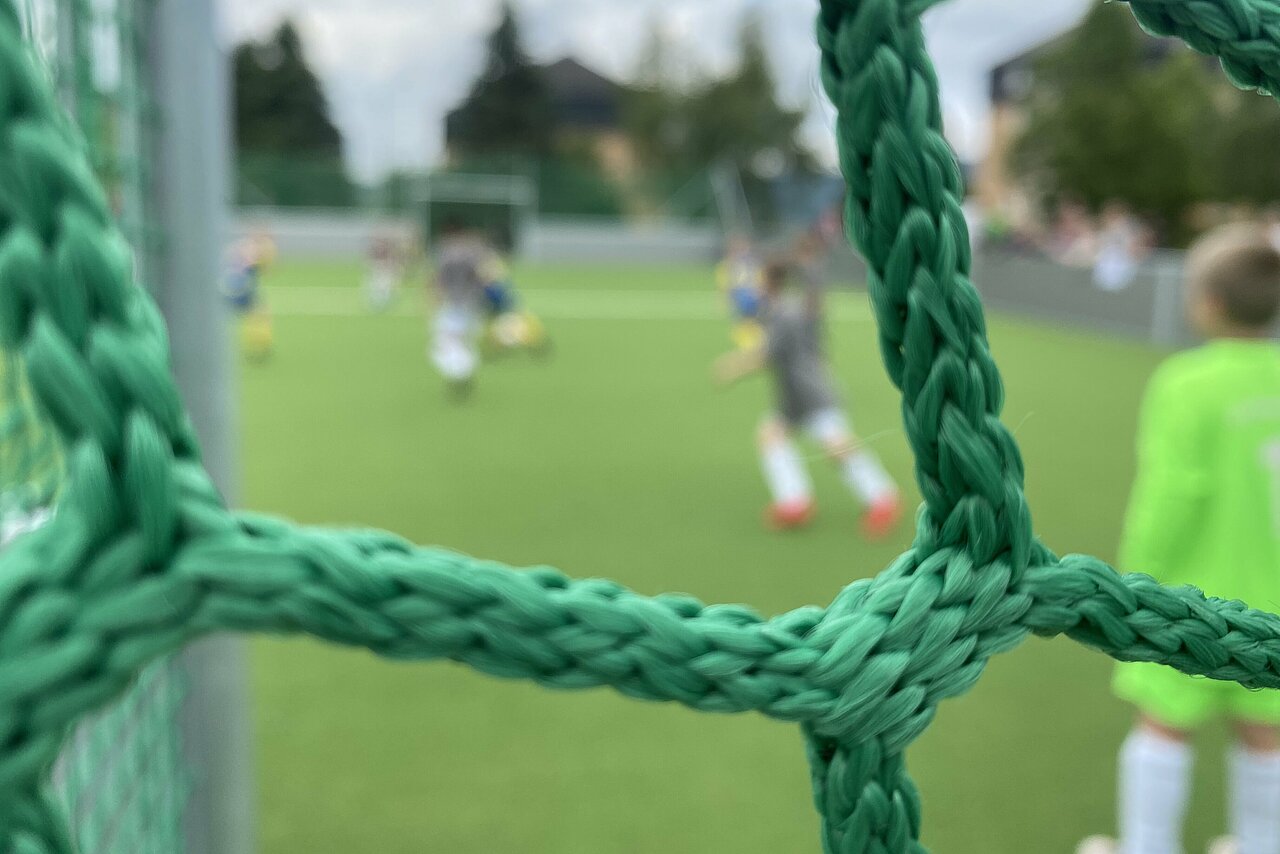 Ein Blick durch Tornetz auf ein spannendes Fußballspiel im Elldus Resort